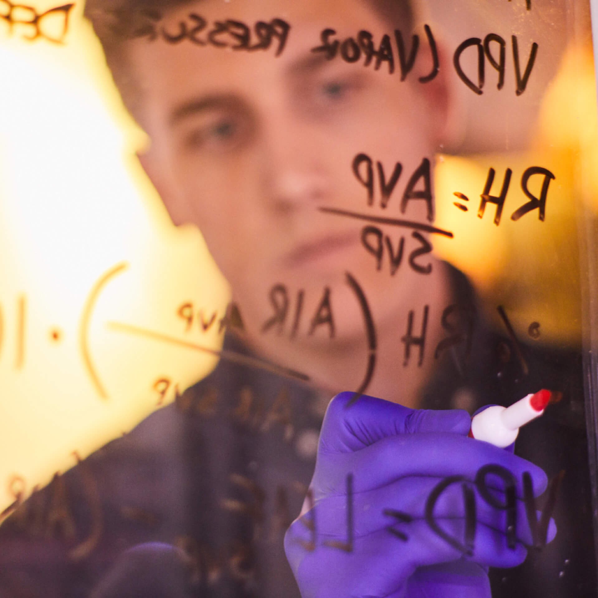 Man is writing on a glass.